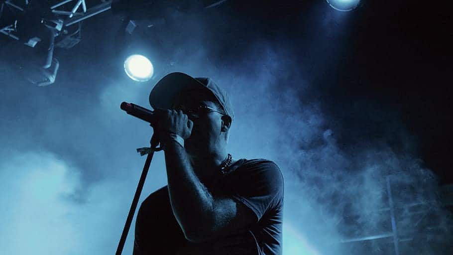 Man singing on stage, holding mic for the best innovation in live sound, showing sound technology and music events